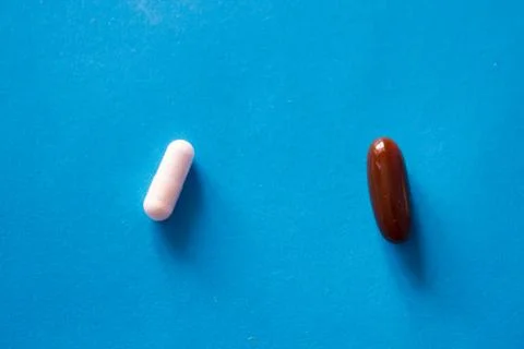 Two pills on blue background Stock Photos