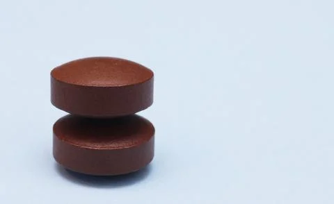 Two pills on a blue background. Stock Photos