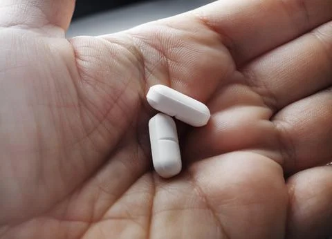 Two pills on palm Stock Photos