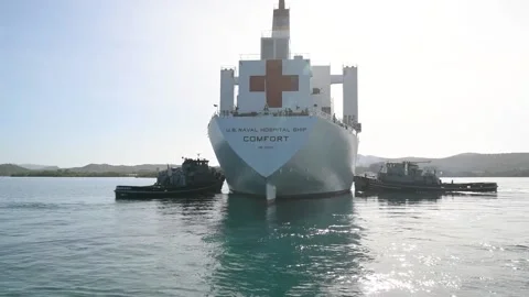 Two pilot ships turning U.S. Navy hospital ship USNS Comfort at Guantanamo Bay Stock Footage 227138772