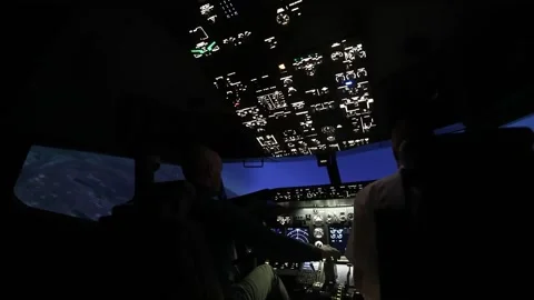 Two pilots in the cockpit during training to fly the aircraft. Back view. Stock Footage 241486426