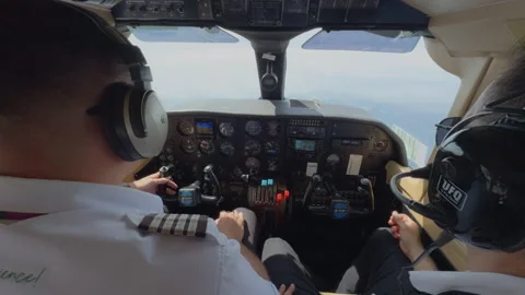Two pilots flying light aircraft with analog instrument panel and GPS. Stock Footage 338364650