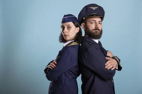 Two pilots stand back to back with crossed arms Stock Photos