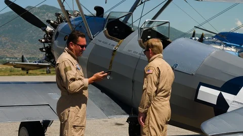 Two pilots in US Navy uniform are preparing for a flight on the retro plane 스톡 동영상 115895122