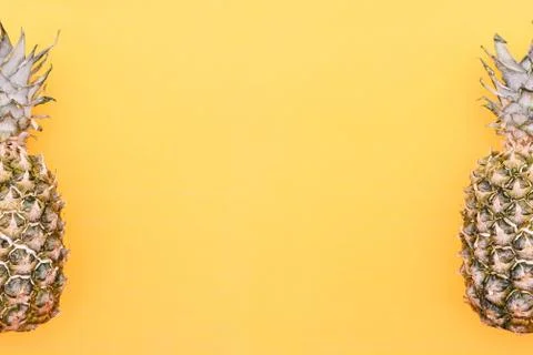 Two pineapple on a bright background. Fruits are located on the edges of the Stock Photos