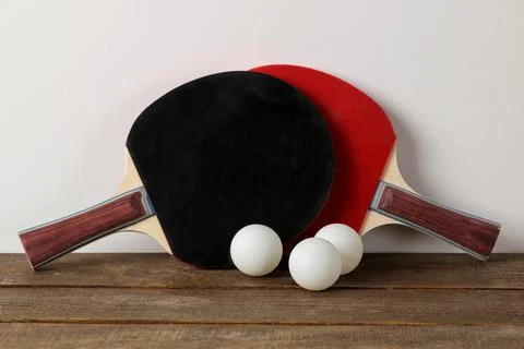 Two ping pong rackets. Rackets for table tennis and a ball on a brown wooden Stock Photos