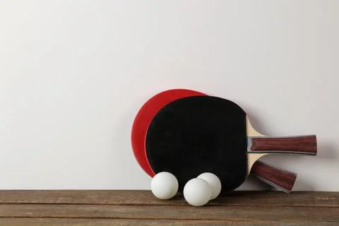 Two ping pong rackets. Rackets for table tennis and a ball on a brown wooden Stock Photos