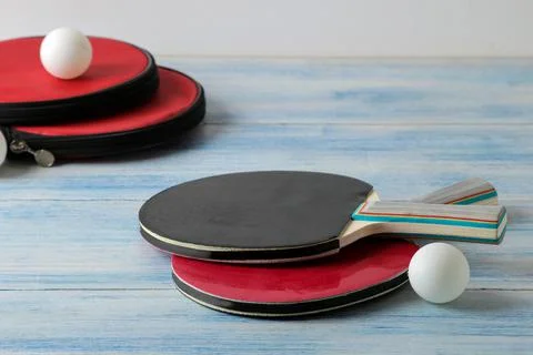 Two ping pong rackets. Table tennis rackets and a ball on a blue wooden table Stock Photos