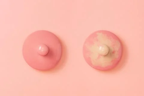 Two pink ceramic lids on a pink background symbolizing the female breast. R.. Stockfoto's