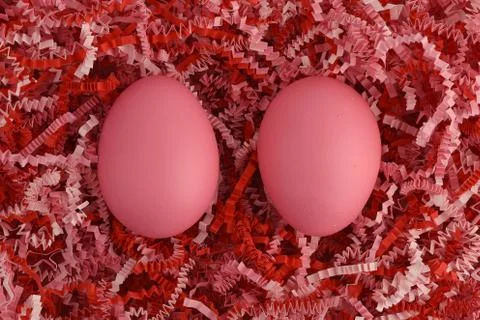 Two pink Easter eggs on striped paper in red and pink tones Stock Photos