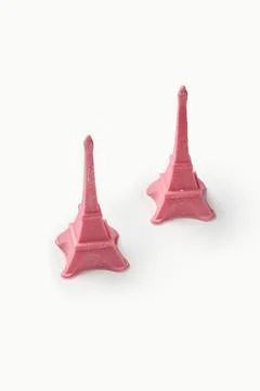 Two pink eiffel tower statues resting on white background Stockfoto's