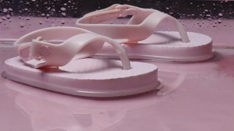 Two pink flip flops are in a pool of pink liquid Stock Footage 276800532