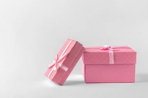 Two pink gift boxes with ribbon and bow isolated on a white or light gray bac Photos