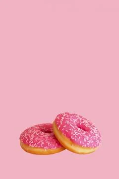 Two pink glazed donuts on a pink background. Copy space. Concept of Doughnut  Stock Illustration