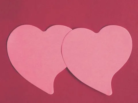 Two pink heart-shaped notepad on red leather background Stock Photos