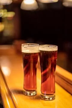 Two pints of beer on bar counter at night Stock Photos