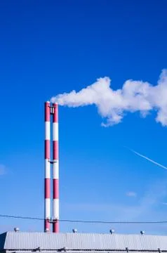 Two pipes smoke against the blue sky Stock Photos
