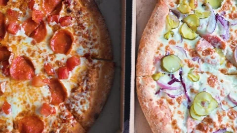 Two pizzas are displayed side by side in a casual setting. One features Stock Footage 338290326