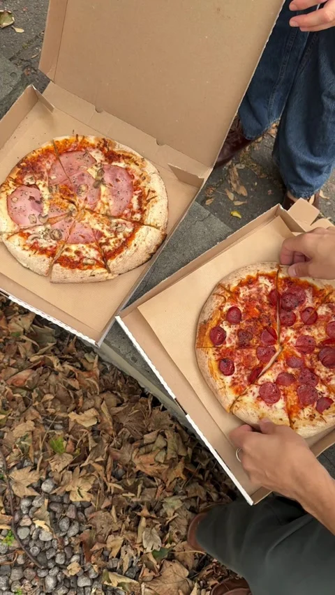 Two pizzas in boxes being opened by people outdoors Video stock 331772255