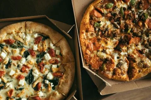 Two pizzas in boxes on table. Stock Photos