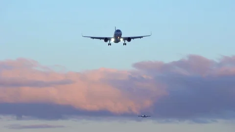 Two planes are flying in the sky. In background blue sky, purple orange clouds Stock-Footage 115653926