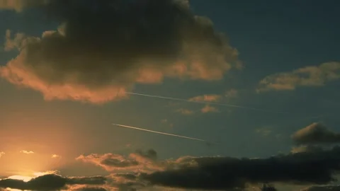 Two planes fly parallel in blue sky with sunlit white clouds and leave trail Stock Footage 306743186