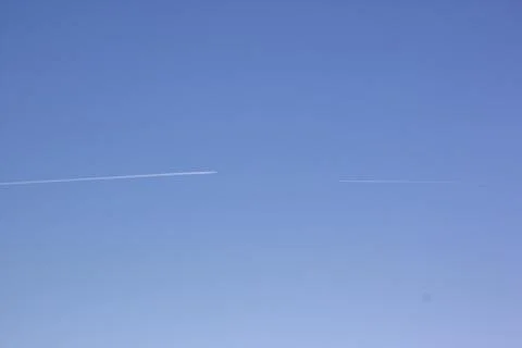 Two planes fly towards each other. Inversion trail of clouds from the plane Stock Photos