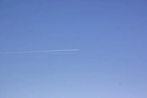 Two planes fly towards each other. Inversion trail of clouds from the plane Stock Photos