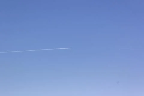 Two planes fly towards each other. Inversion trail of clouds from the plane Stock Photos