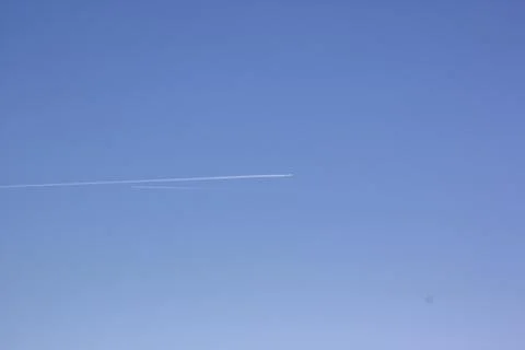 Two planes fly towards each other. Inversion trail of clouds from the plane Stock Photos