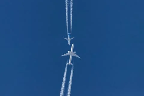 Two planes flying on opposite courses meet in the sky Stock Photos