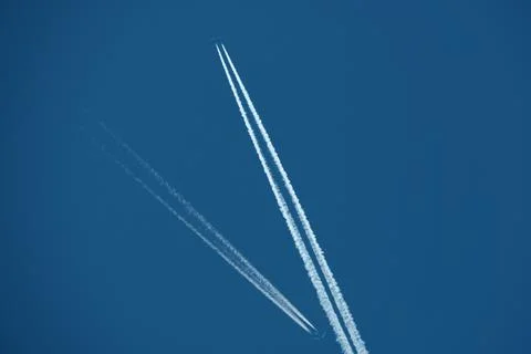 Two planes in the sky, two airplane tracks in the blue sky, contrails Stock Photos