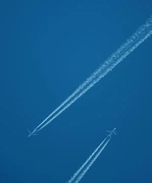 Two planes in the sky, two airplane tracks in the blue sky, contrails Stock-Fotos