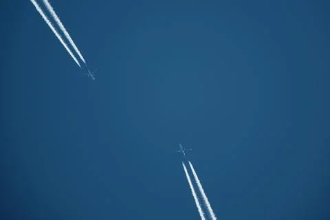 Two planes in the sky, two airplane tracks in the blue sky, contrails Stock Photos