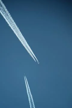 Two planes in the sky, two airplane tracks in the blue sky, contrails Stock Photos