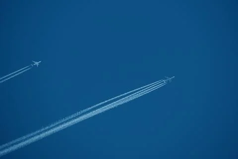 Two planes in the sky, two airplane tracks in the blue sky, contrails Stock Photos