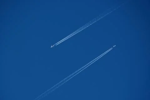 Two planes in the sky, two airplane tracks in the blue sky, contrails 스톡 사진