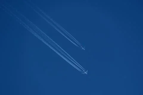 Two planes in the sky, two airplane tracks in the blue sky, contrails Foto stock