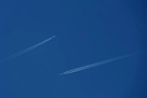 Two planes in the sky, two airplane tracks in the blue sky, contrails Stock Photos
