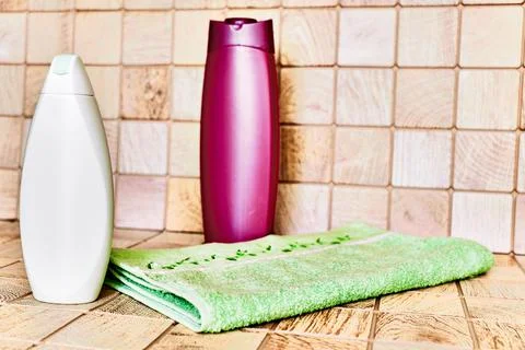Two plastic bottles for detergents and shampoos, a towel on a pink background Stock Photos