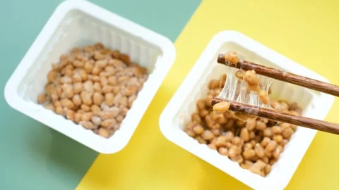 Two plastic boxes with natto beans on green and yellow background top view. Stock Footage 291906352