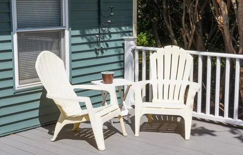 Two plastic chairs in the cornor of a new composite deck Stock Photos