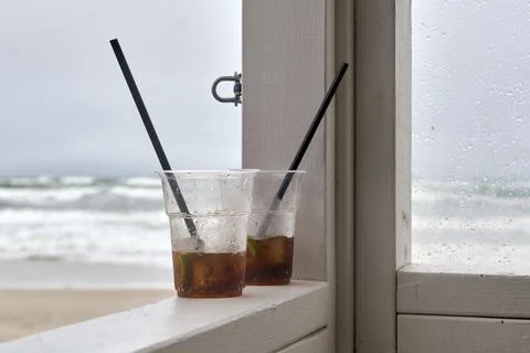 Two plastic cups with iced drinks and black straws sitting on a white wooden  Stock Photos