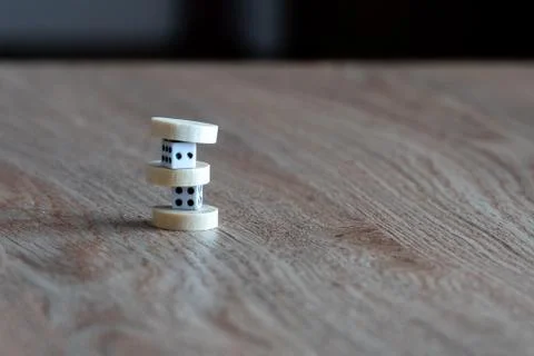 Two plastic dice and backgammon chips on a table. Stock Photos