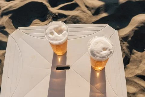 Two plastic mugs with cold refreshing beverage beer on summer bar table on co Foto stock