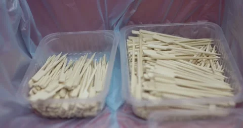 Two plastic trays filled with wooden bamboo skewers on foil in a food Vídeo Stock 339995375