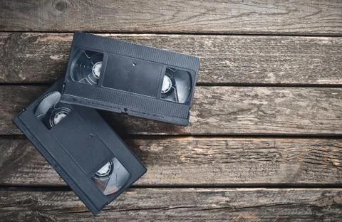 Two plastic video cassettes from the 80s on a rustic wooden table. Top view. Stock Photos