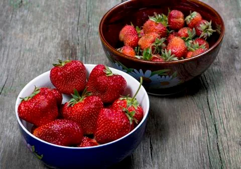 Two plates with large strawberry on a table Stock Photos