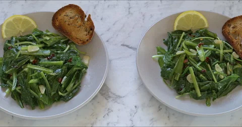 Two plates with sautéed chicory greens. Camera slide. Stock Footage 312869036