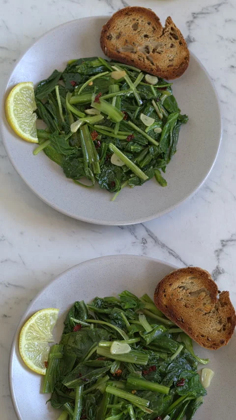 Two plates with sautéed chicory greens. Camera slide. Vertical video. Stock Footage 312869039